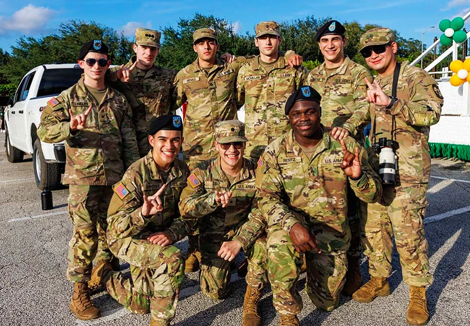 A group of people in camouflage smile for the camera
