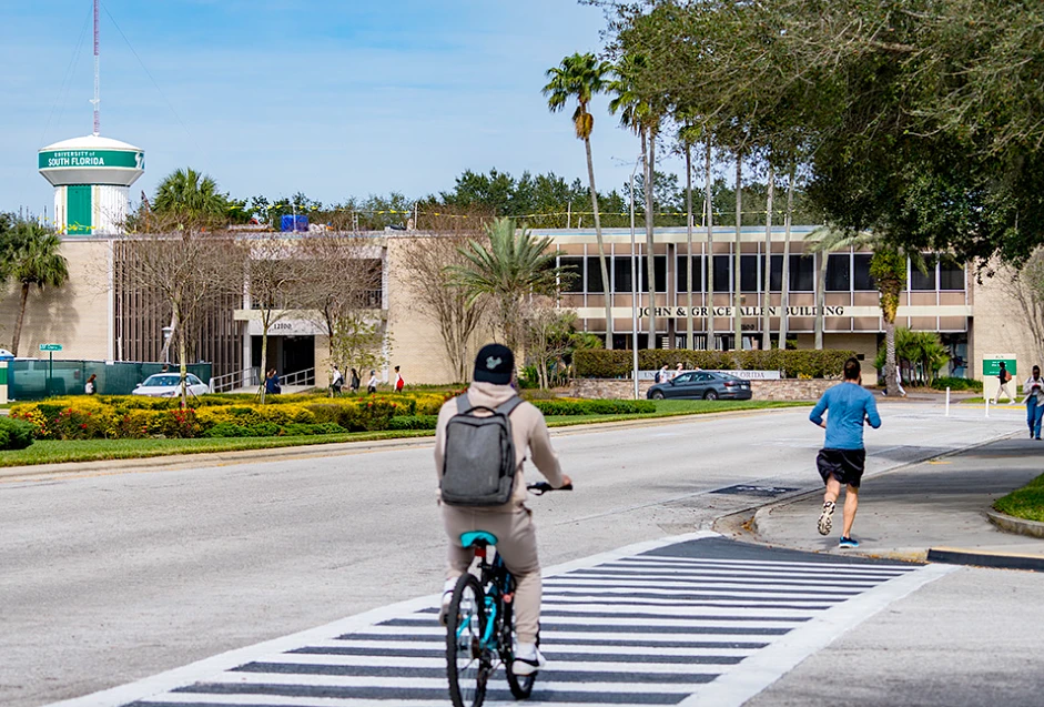 A person bikes on a sidewalk