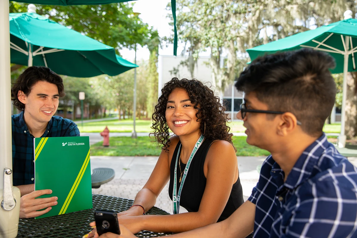 image of USF student sitting at a table outside